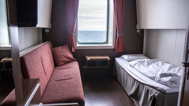 tiny cruise cabin with a single bed and couch