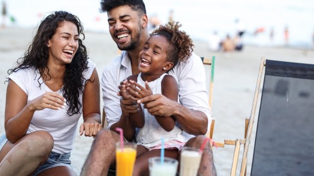 Young family laughing on beach