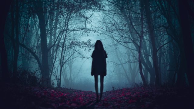 Scary ghost girl standing in the woods