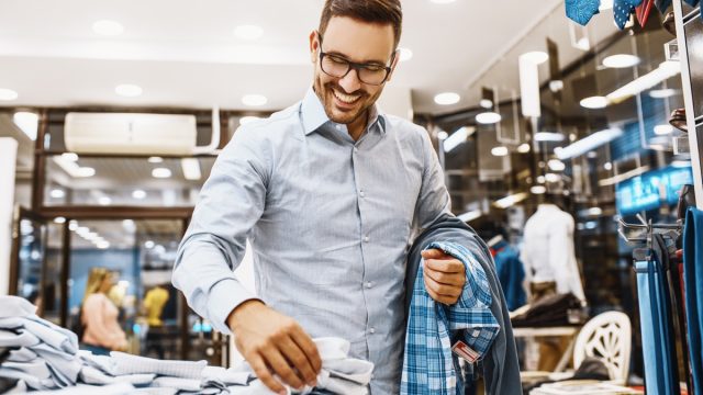 30-something white man in glasses shopping for clothing