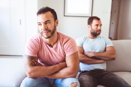 mixed race gay couple on the couch having a fight