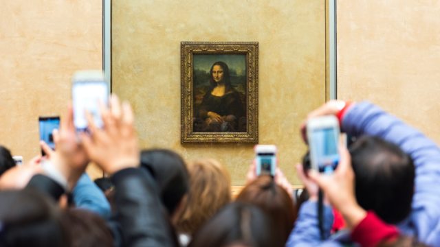 people trying to take a picture of the mona lisa