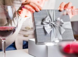 woman opening silver jewelry box at dinner