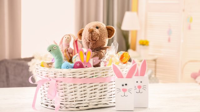 large white easter basket with pink bow on white table