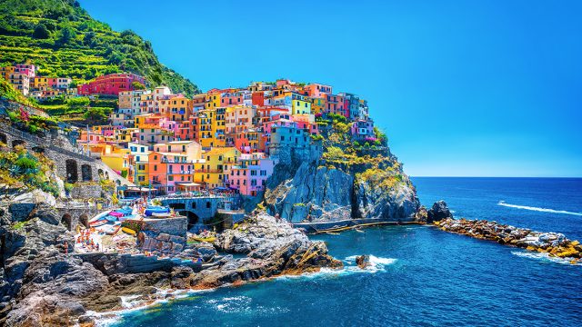 pastel colored buildings on a seaside cliff in italy