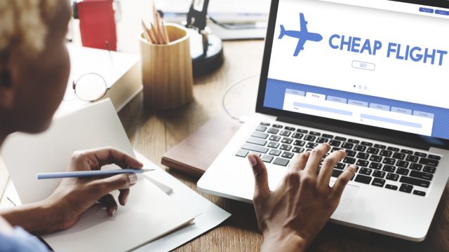 woman checking cheap flights on her laptop
