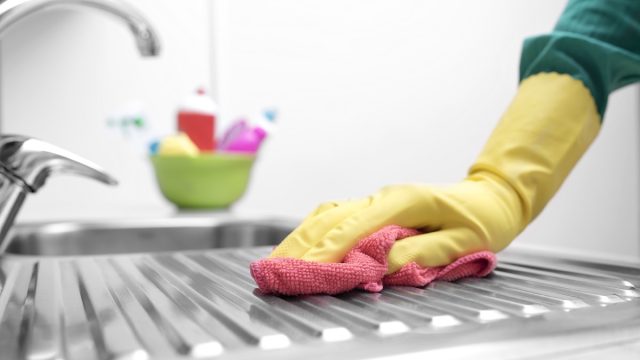 hand in yellow gloves cleaning kitchen