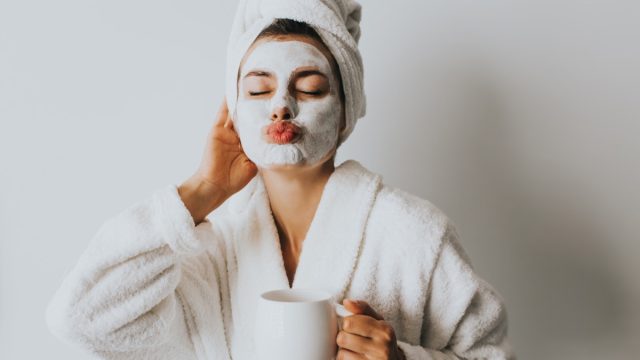 Woman with an at home facial ad coffee