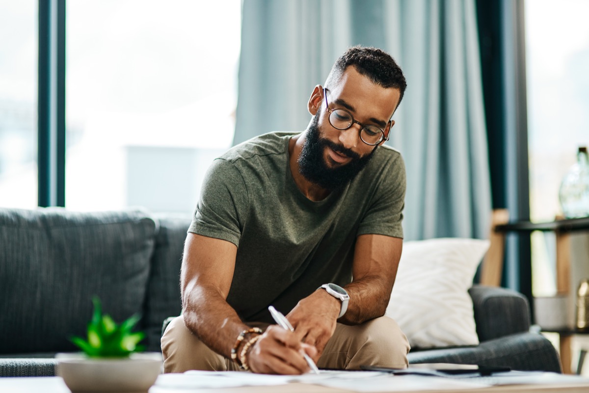 Man sitting on couch and writing