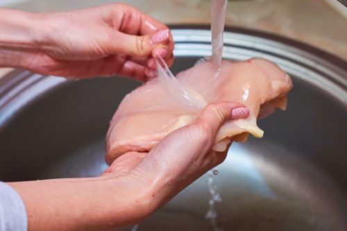 washing raw chicken in sink