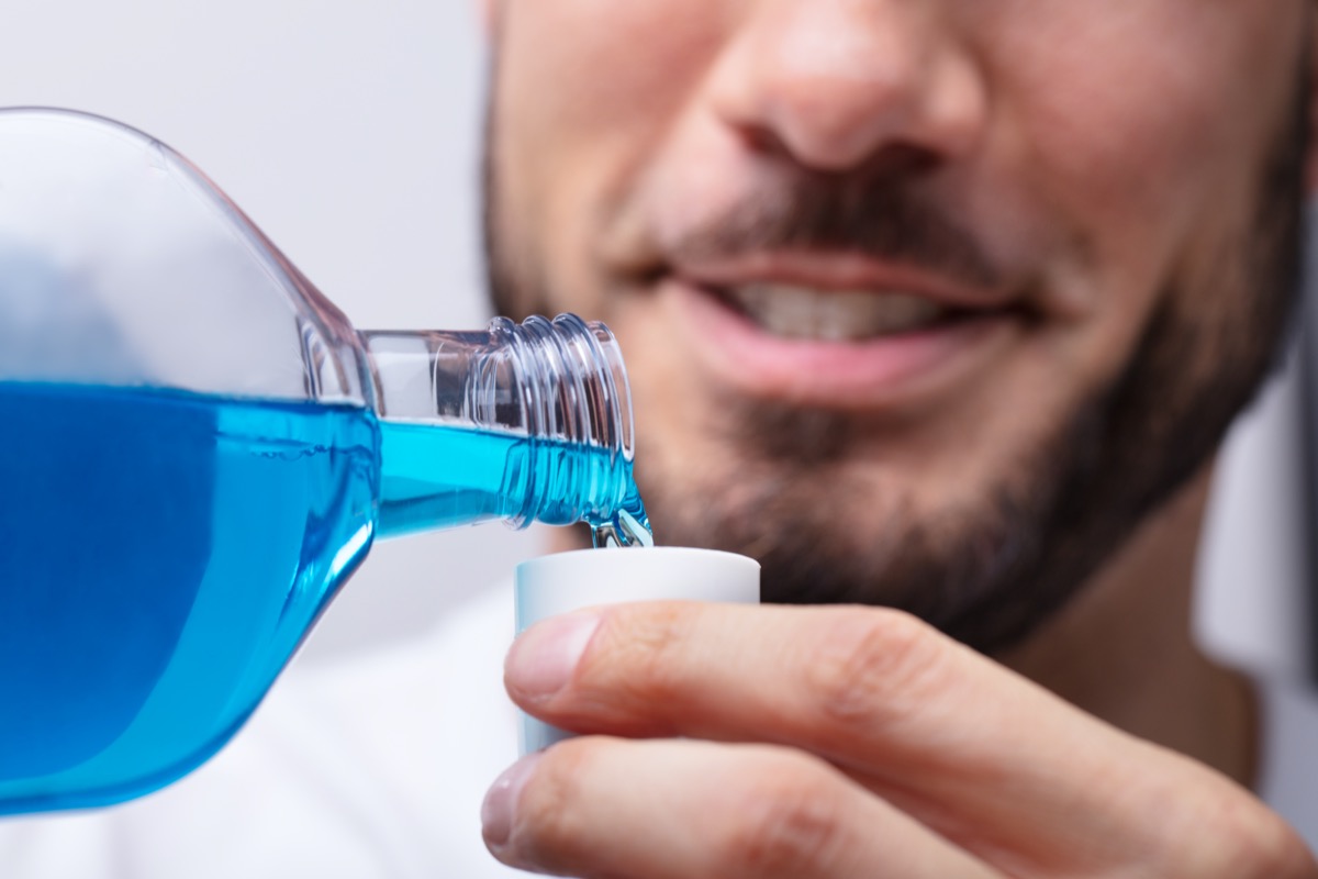 closeup of man pouring mouthwash