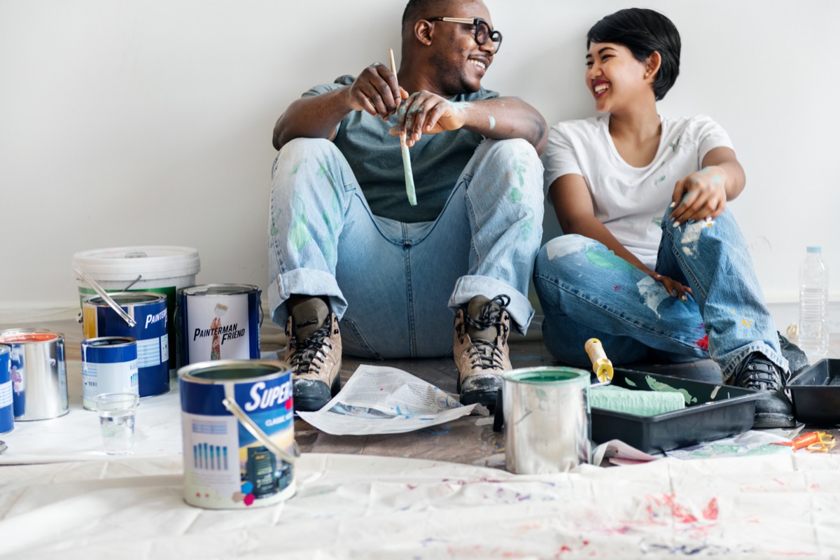 a man and woman paint walls together