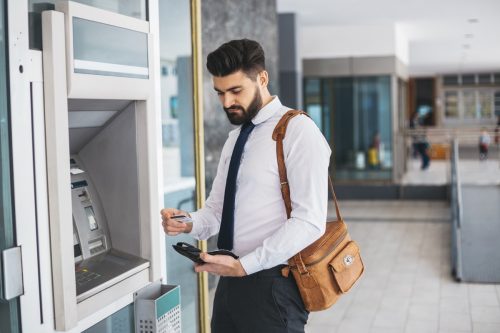 Businessman using ATM