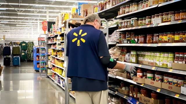 older male walmart employee stocking shelves