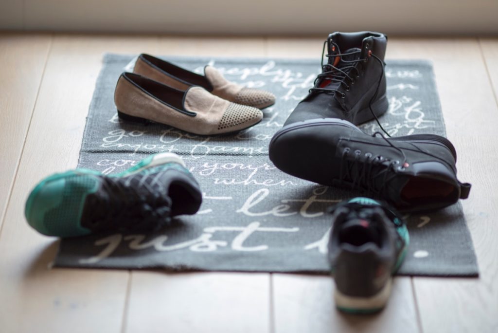 pile of shoes on door mat