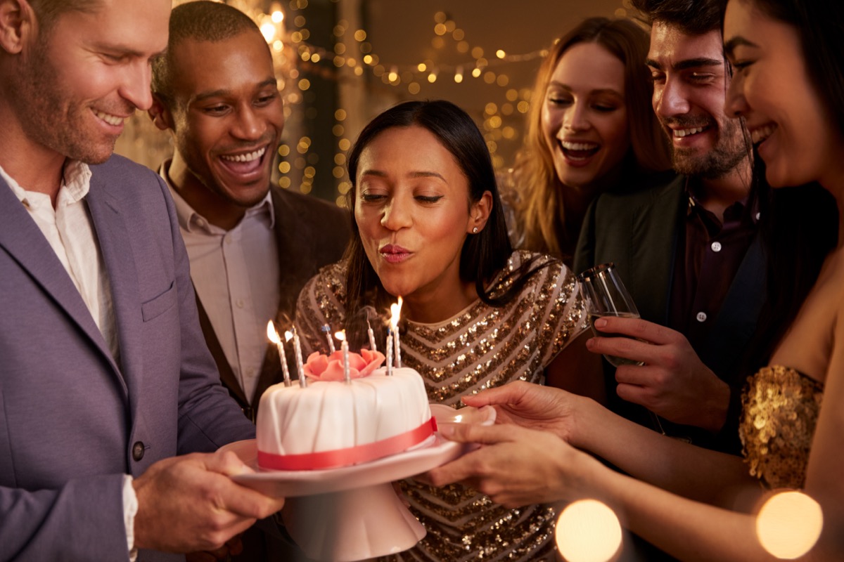 Woman blowing out candle at birthday