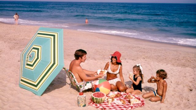 family has a beach picnic in the 1970s