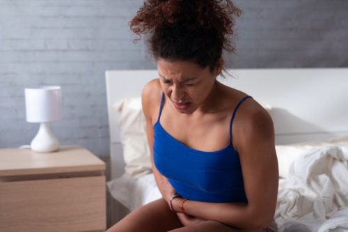 woman in pain clutching stomach