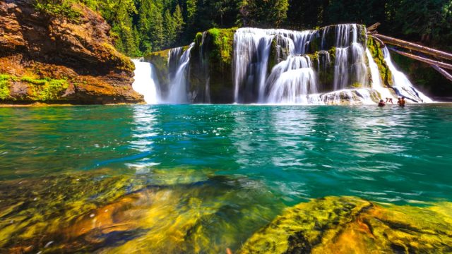 turquoise swimming hole with a waterfall