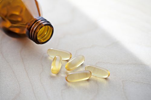 Vitamins spilling from a bottle onto a coutnertop