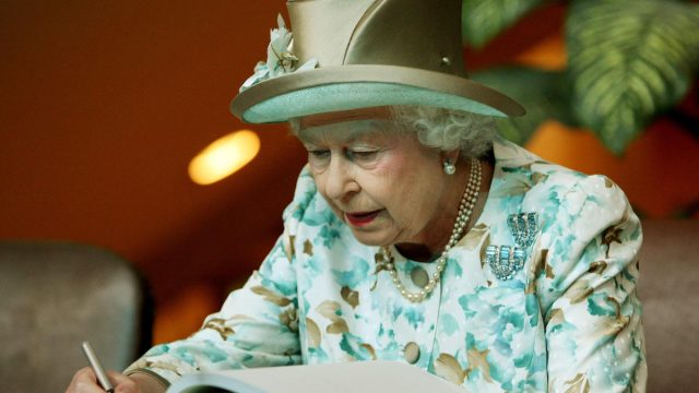 Queen Elizabeth II, 84, of Britain, signs a guest book after she addressed the General Assembly at the United Nations on July 6, 2010 in New York.