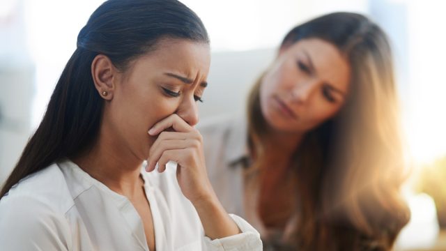 Shot of two young businesswomen talking to each other while being seated in the office at work