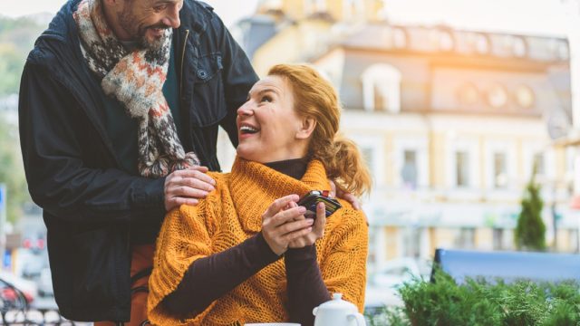 older white man greeting older white woman outside