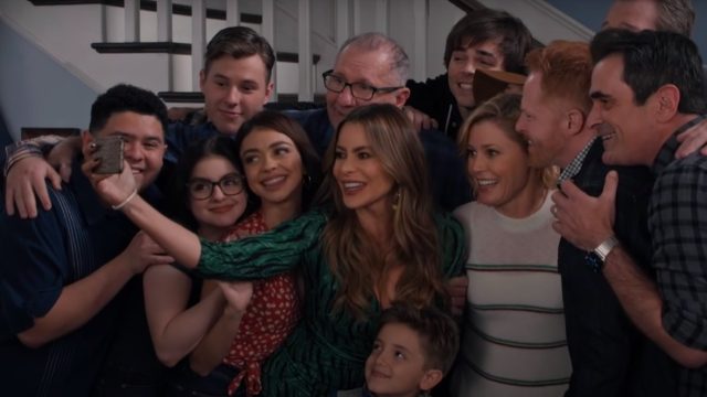 the cast of Modern Family taking a photo together in their final episode