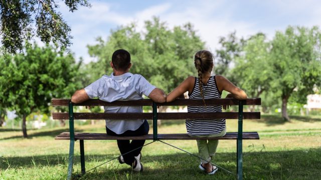 Couple sitting together on a bench in the park