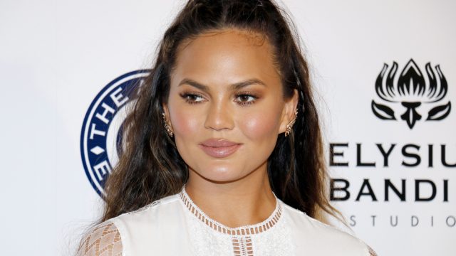Chrissy Teigen in a white dress on the red carpet