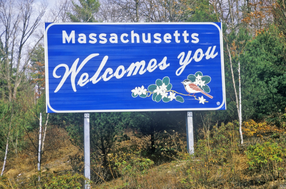 Blue "Massachusetts Welcomes You" sign in front of green trees