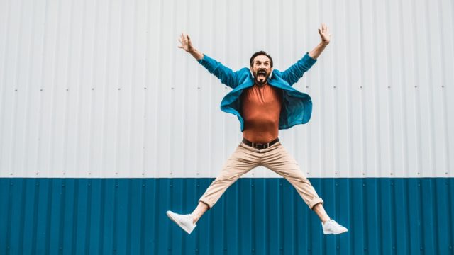 white man jumping for joy outside