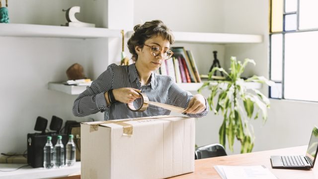 Young freelance woman sending a package to client.
