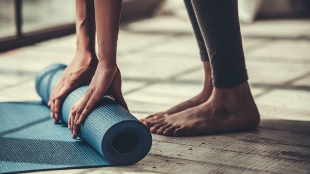 woman rolling up yoga mat