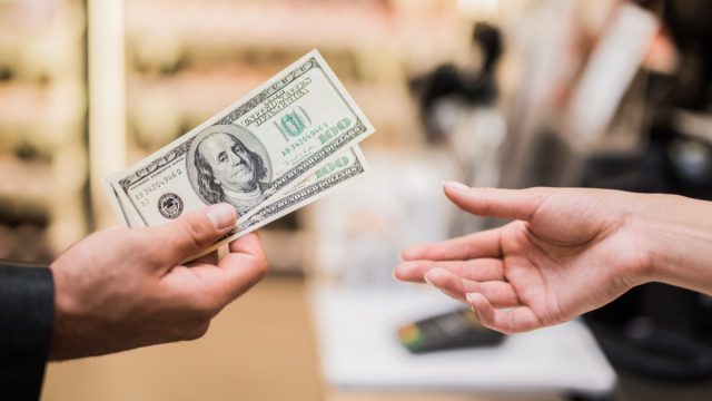 man paying with cash in store