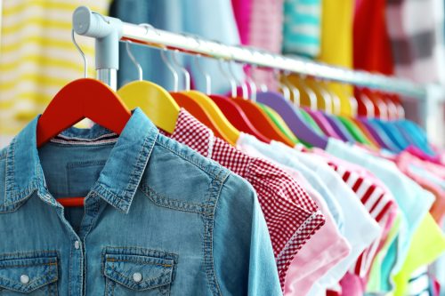 Children clothes hanging on hangers in the shop