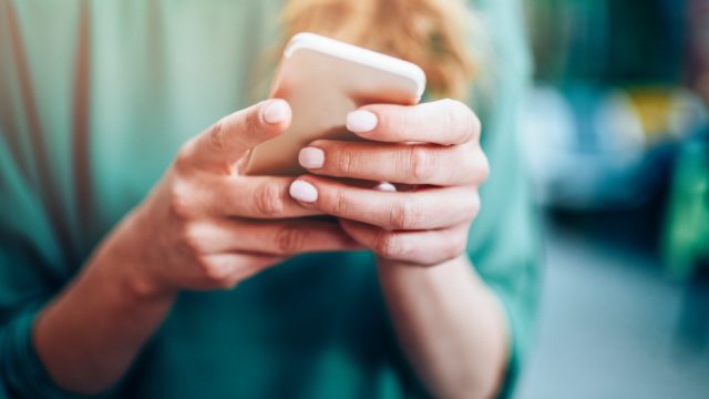 Close-up of an unrecognizable woman using smart phone