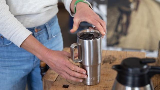 closeup of woman's hand securing lid on yeti travel mug