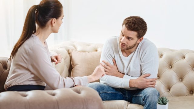 man looking at woman and woman towards to the man on a couch