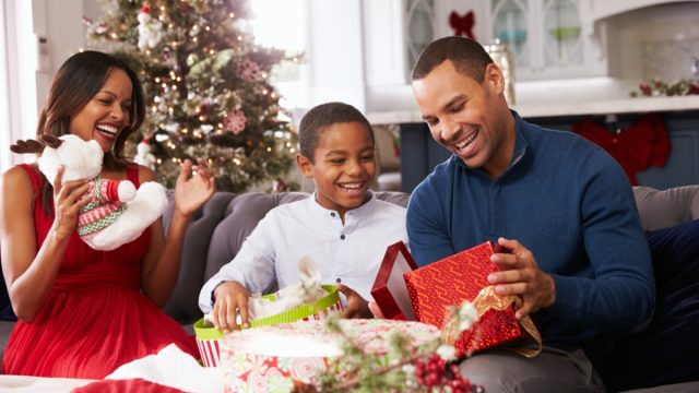man opening presents with family