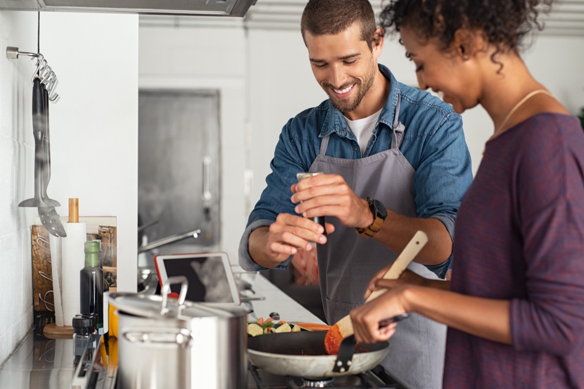 young couple making dinner together