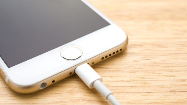 Smartphone charging with power bank on wood board table