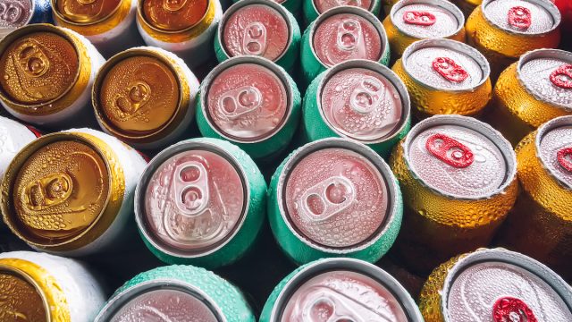 Metal cans with ice cubes in mini refrigerator