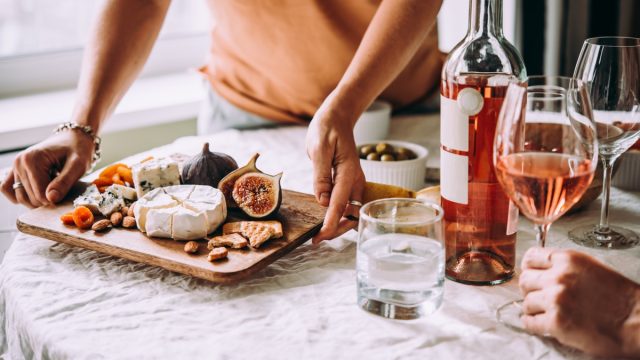 friends sharing some wine, fruit, and cheese at a dinner party