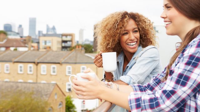 two women drinking coffee on rooftop