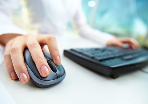close up on woman's hand using computer mouse