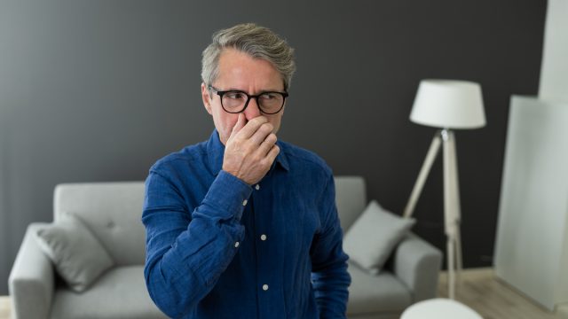 man smells something bad in his house