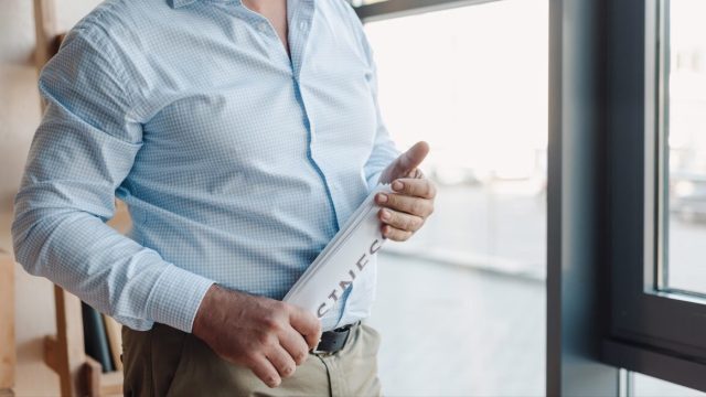 Man holding rolled newspaper