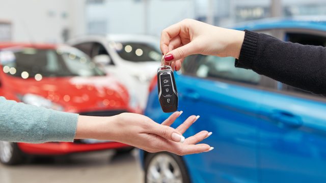 Hands exchanging keys for a new car