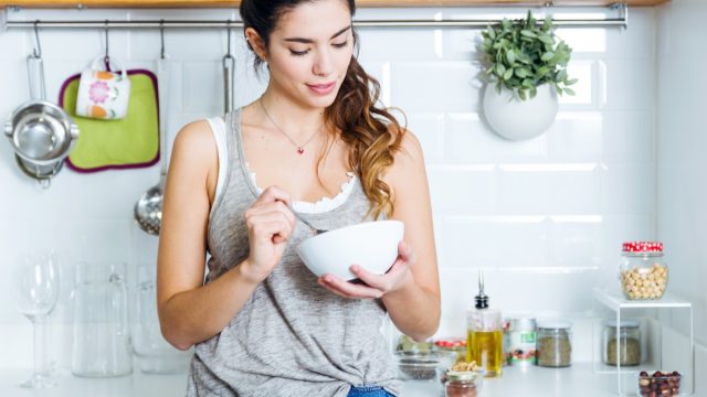 woman eating in kitchen